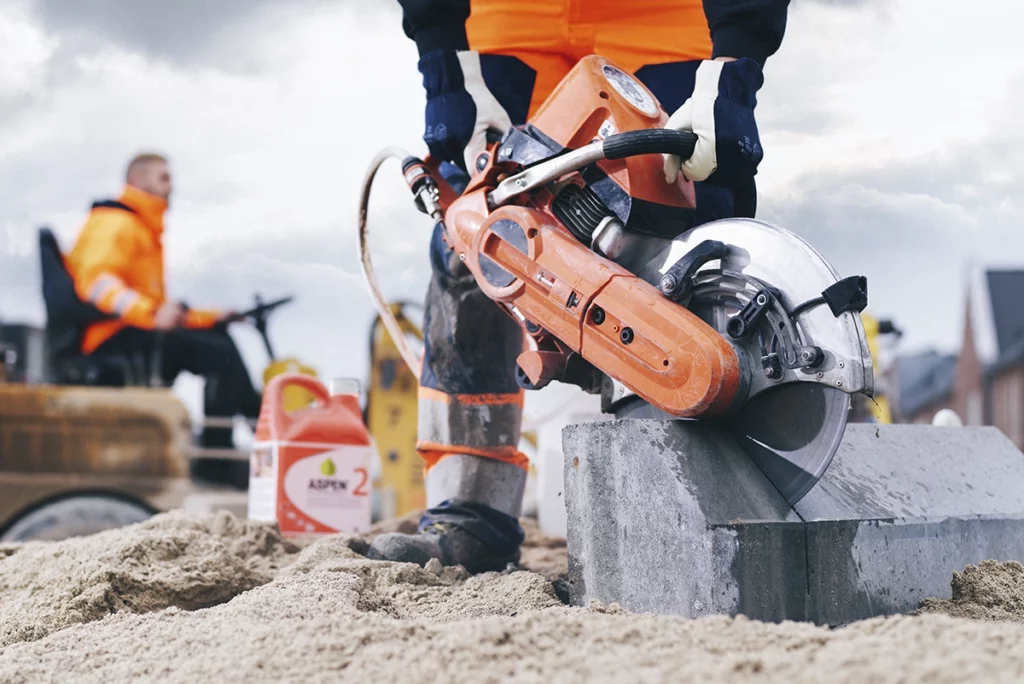 Man werkt buiten met een doorslijper gevuld met Aspen 2 alkylaatbenzine