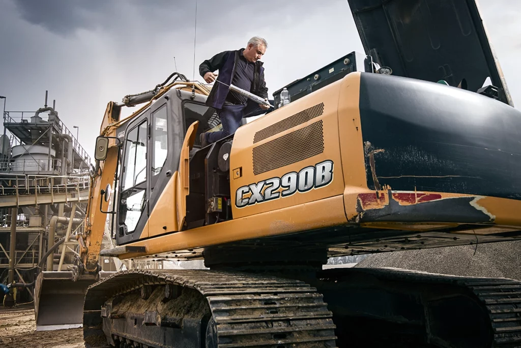 Man op een graafmachine voert een olietest uit