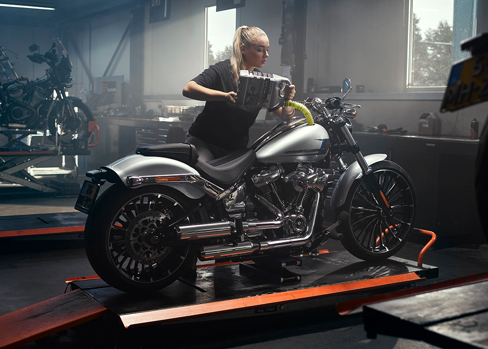 Vrouw in garage tankt motor met Bike Fuel 4