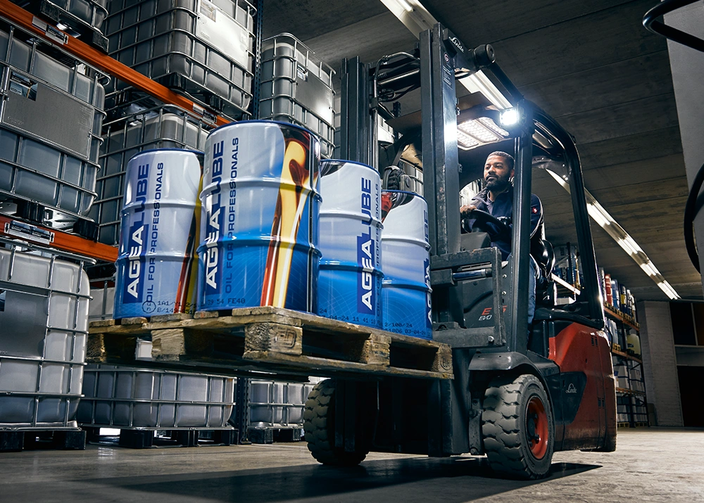 Man op een heftruk in het warehouse met een pallet Agealube drums