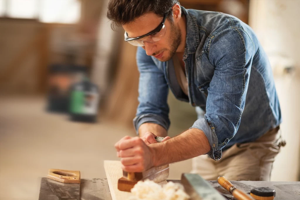 Man aan het houtbewerken in de schuur met een can Firelux Eco op de achtergrond